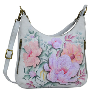 Anuschka style 662, handpainted Convertible Slim Hobo With Crossbody Strap. Bel Fiori Painted in Grey Color. Featuring inside zippered wall pocket, one open wall pocket, two multipurpose pockets with gusset and rear full length zippered pocket, slip in cell pocket.