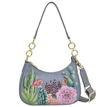Load image into Gallery viewer, Anuschka style 701, Small Convertible Hobo. Desert Garden painting in grey color. Featuring Rear full length zip pocket &amp; Removable adjustable crossbody web strap.
